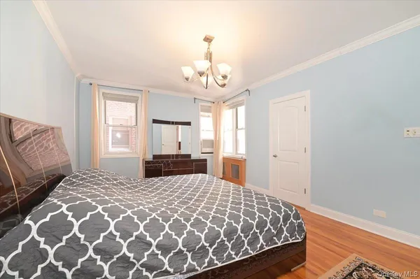 a bedroom with a large bed and a chandelier