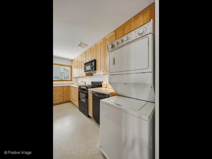 a view of washer and dryer with kitchen in it