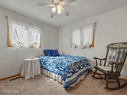 a bedroom with a bed chair and window