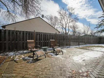 a view of backyard with wooden fence and trees