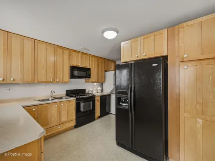 a kitchen with stainless steel appliances granite countertop a refrigerator stove and sink