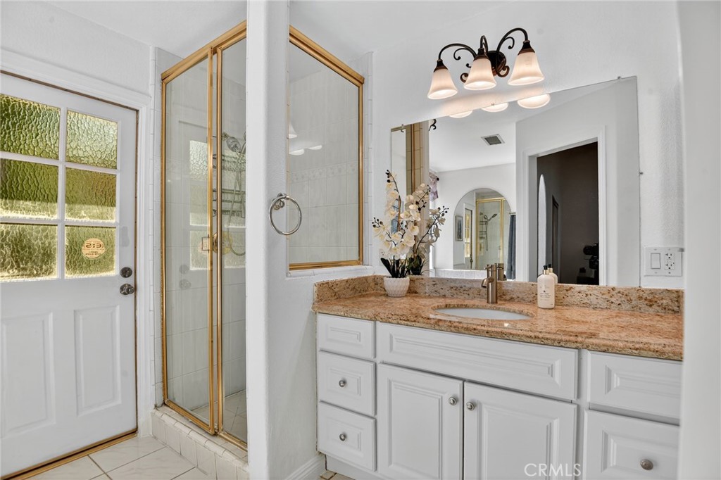 20122 Candleflame Court Walnut, CA 91789 - Photo 19 of 61 a bathroom with a granite countertop sink a mirror and shower