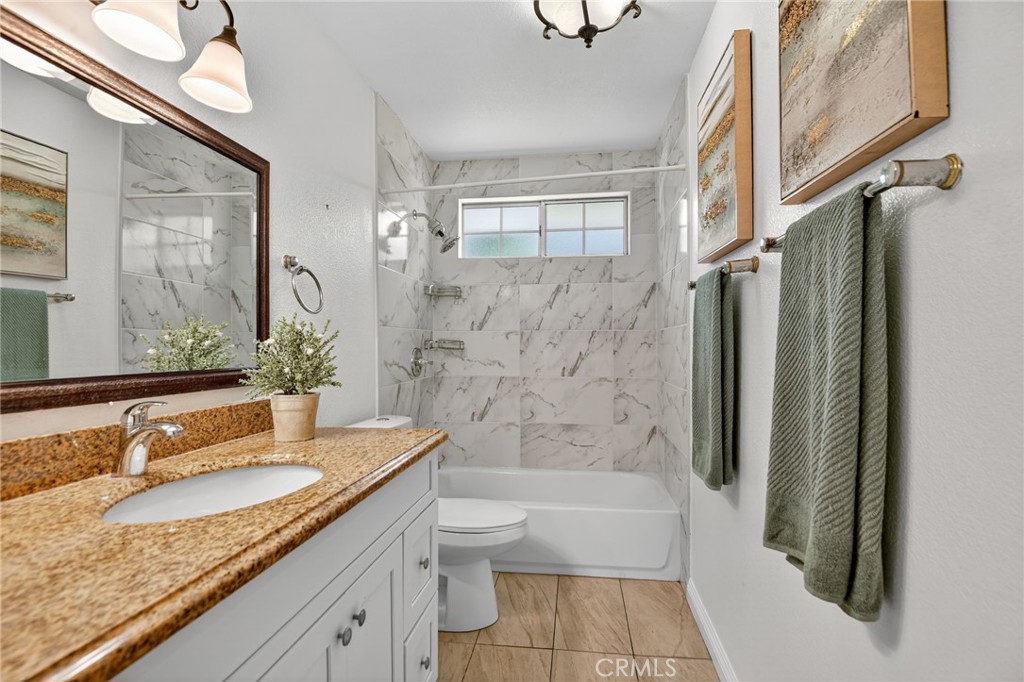 20122 Candleflame Court Walnut, CA 91789 - Photo 20 of 61 a bathroom with a granite countertop sink a toilet a mirror a bathtub and shower