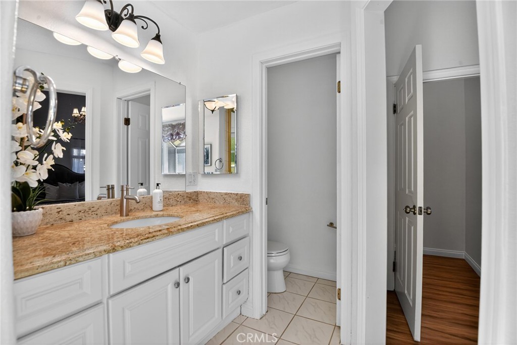 20122 Candleflame Court Walnut, CA 91789 - Photo 27 of 61 a bathroom with a granite countertop sink a mirror and a shower