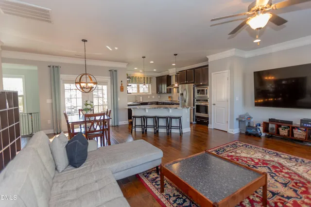 a living room with furniture a flat screen tv and kitchen view