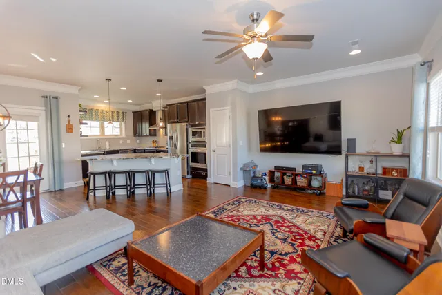a living room with furniture kitchen view and a flat screen tv