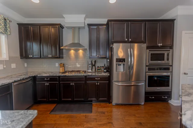 a kitchen with stainless steel appliances granite countertop a refrigerator and a sink