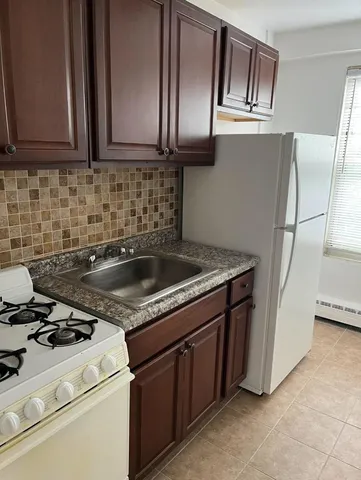 a kitchen with granite countertop a sink stove and refrigerator