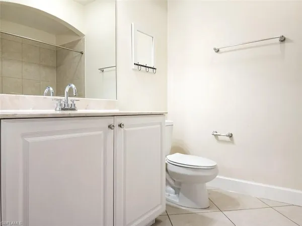 a bathroom with a granite countertop sink toilet and a mirror