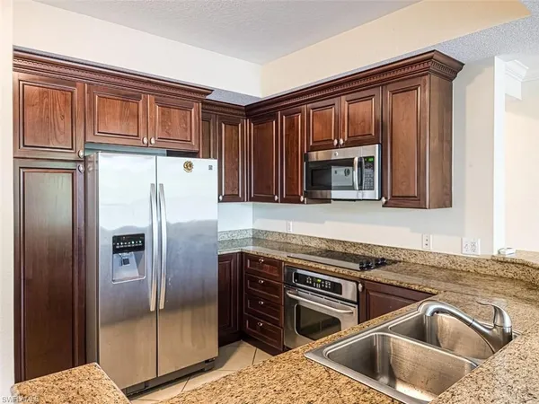 a kitchen with stainless steel appliances granite countertop a refrigerator and a sink