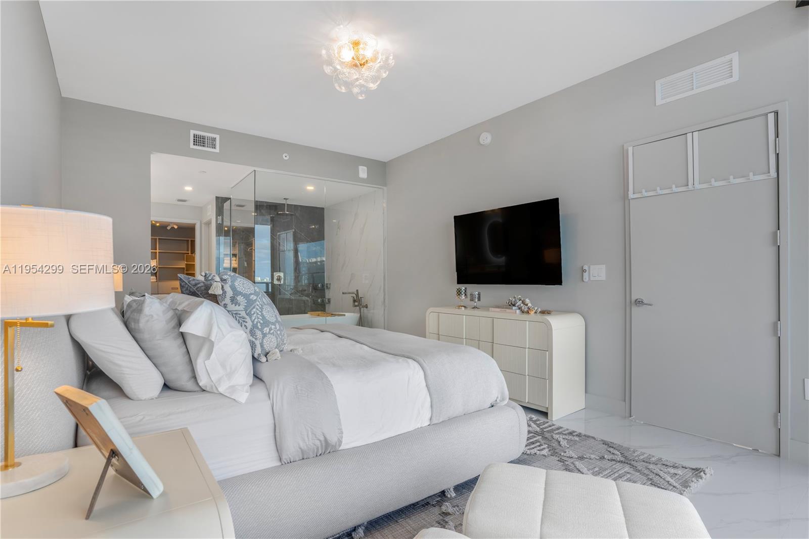 700 Northeast 24th Street, Unit 901 Miami, FL 33137 - Photo 22 of 59 a spacious bedroom with a bed and a flat screen tv
