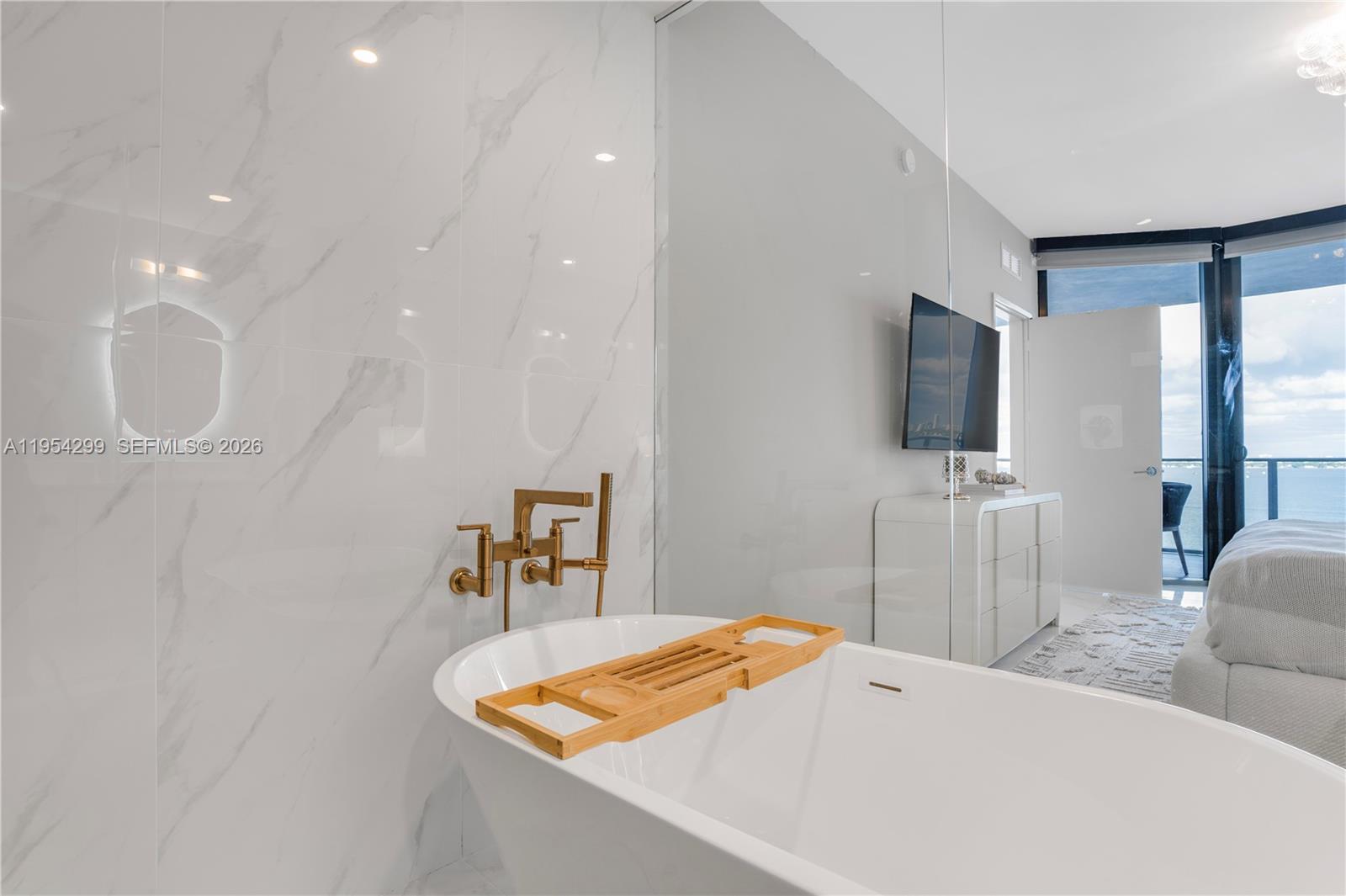 700 Northeast 24th Street, Unit 901 Miami, FL 33137 - Photo 26 of 59 a living room with furniture and a flat screen tv