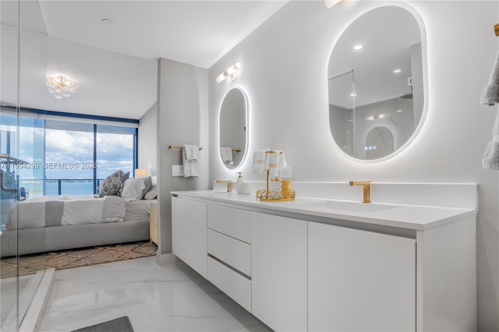 700 Northeast 24th Street, Unit 901 Miami, FL 33137 - Photo 29 of 59 a en suite bathroom with a double vanity sink and a mirror