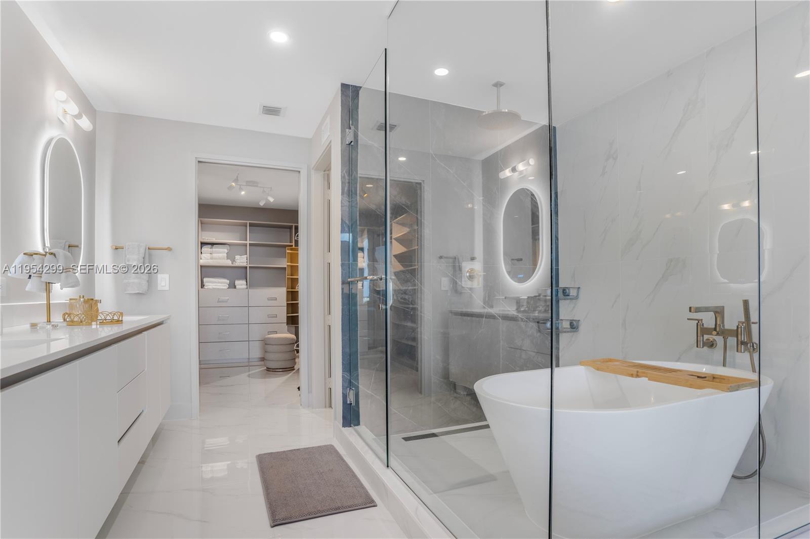 700 Northeast 24th Street, Unit 901 Miami, FL 33137 - Photo 30 of 59 a bathroom with a tub a sink a mirror and a shower