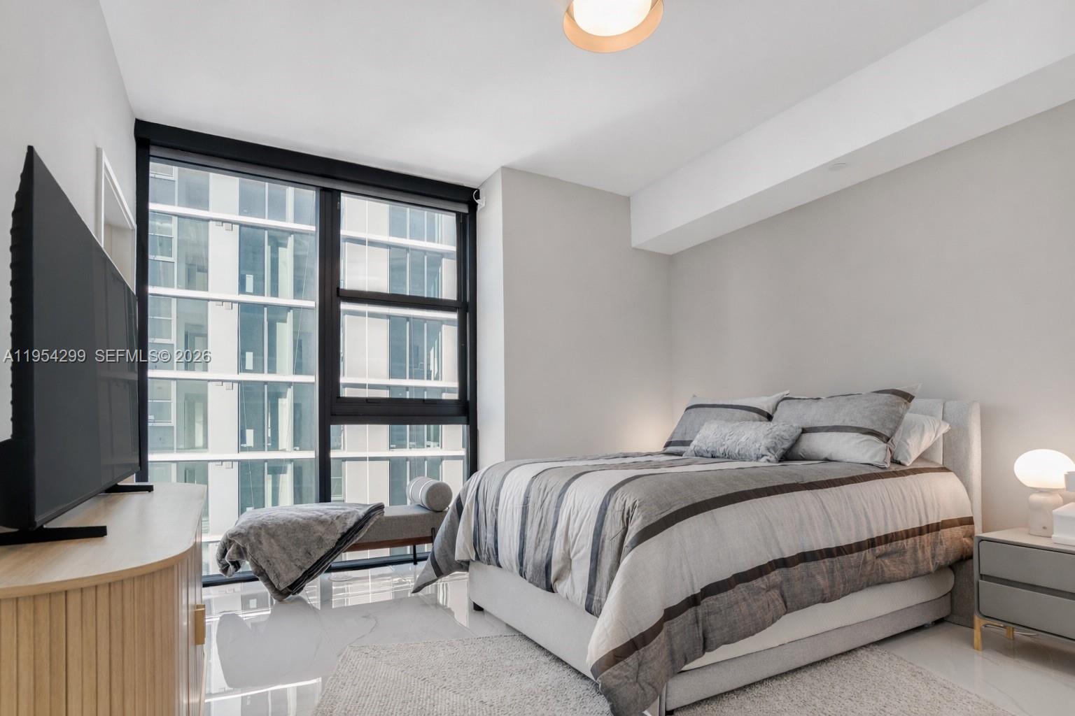 700 Northeast 24th Street, Unit 901 Miami, FL 33137 - Photo 44 of 59 a bedroom with a bed and flat screen tv