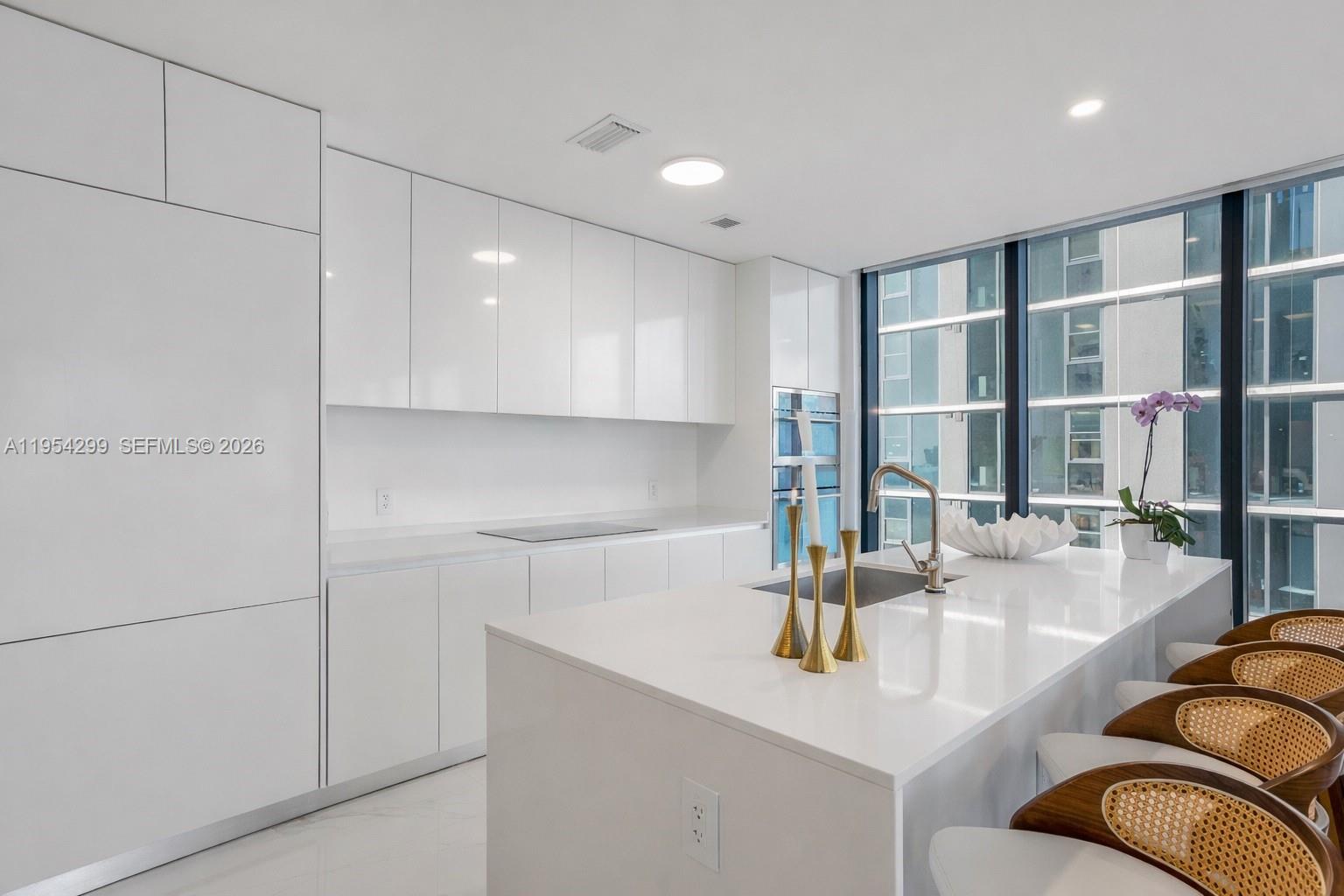 700 Northeast 24th Street, Unit 901 Miami, FL 33137 - Photo 5 of 59 a kitchen with stainless steel appliances granite countertop a sink and a refrigerator