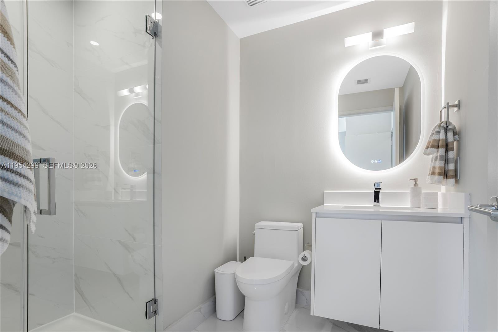 700 Northeast 24th Street, Unit 901 Miami, FL 33137 - Photo 52 of 59 a bathroom with a toilet sink and mirror