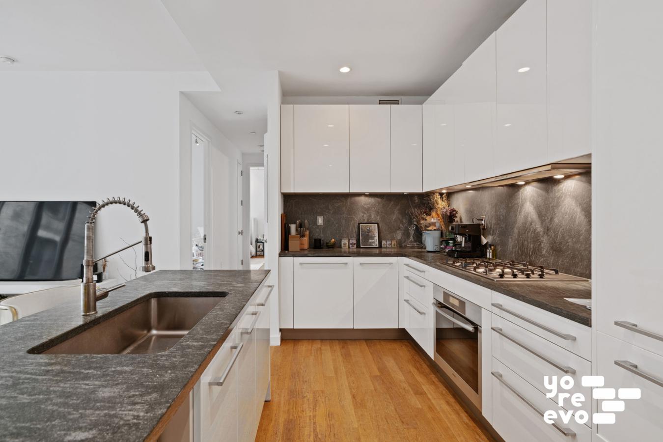 4 West 21st Street, Unit 7A Manhattan, NY 10010 - Photo 3 of 9 a kitchen with granite countertop a sink stainless steel appliances and cabinets