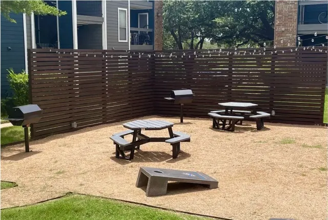 a view of a patio with table and chairs with wooden floor and fence