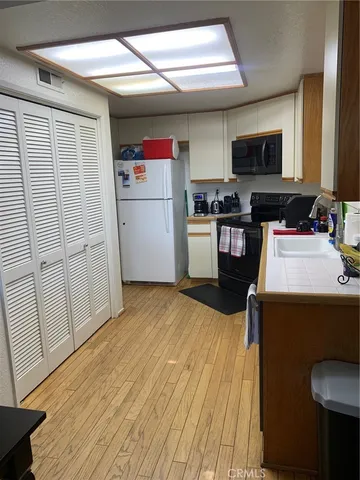 a kitchen with a refrigerator a stove and wooden floor