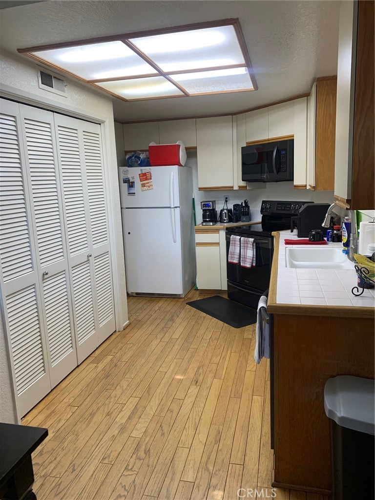 15 Elmbrook, Unit 52 Aliso Viejo, CA 92656 - Photo 5 of 10 a kitchen with a refrigerator a stove and wooden floor