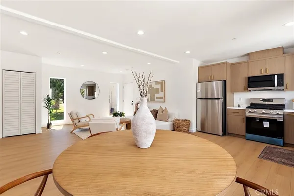 a kitchen with a refrigerator and a dining table