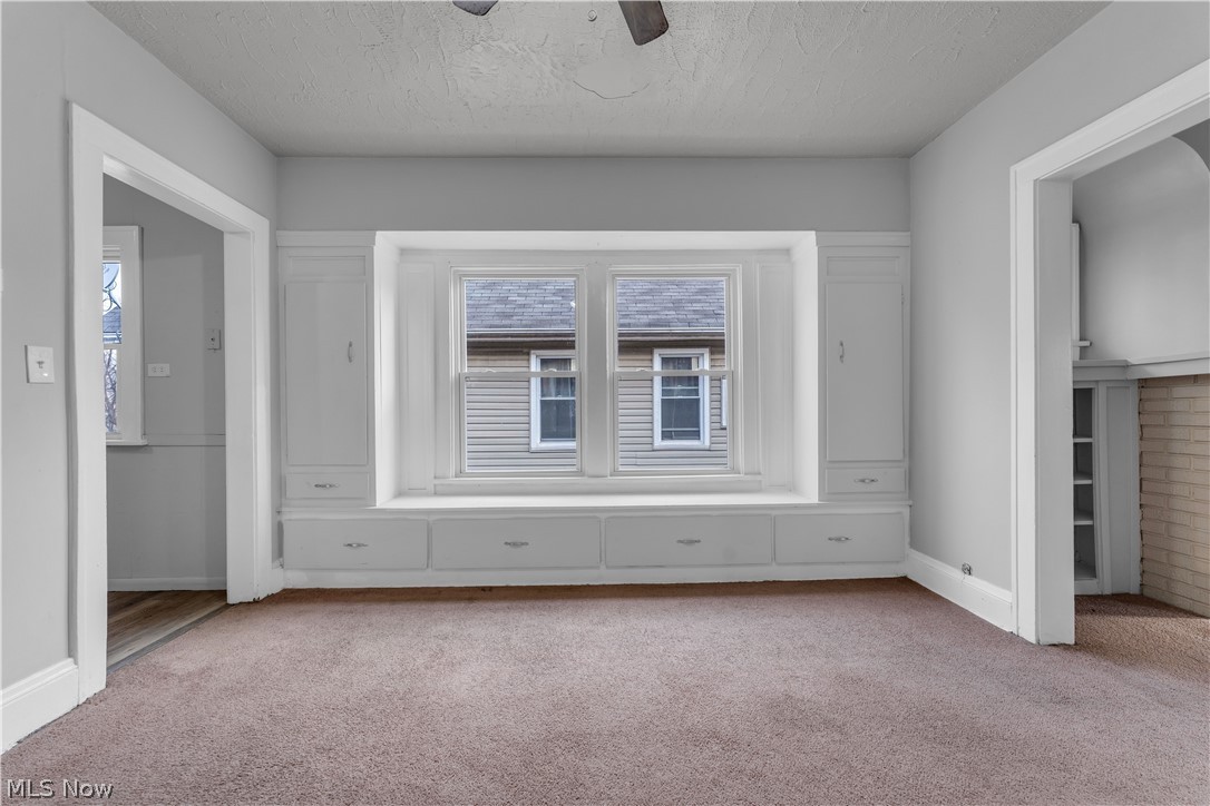 860 Greyton Road Cleveland Heights, OH 44112 - Photo 19 of 31 Empty room with light colored carpet and ceiling fan