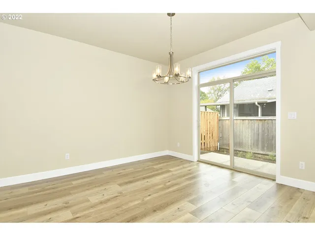 an empty room with wooden floor and door