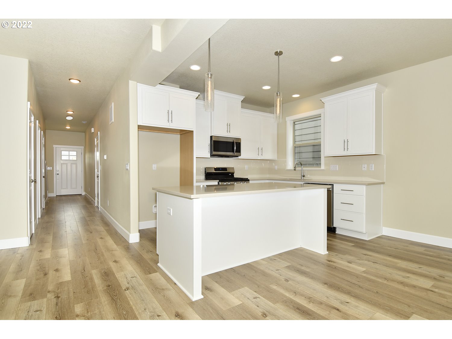 4791 Southwest 179th Avenue Beaverton, OR 97078 - Photo 10 of 27 a kitchen with stainless steel appliances granite countertop a refrigerator a oven a sink and white cabinets with wooden floor