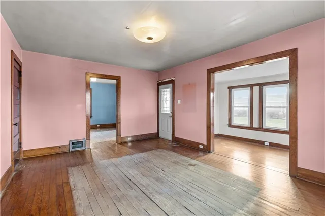 a view of empty room with wooden floor