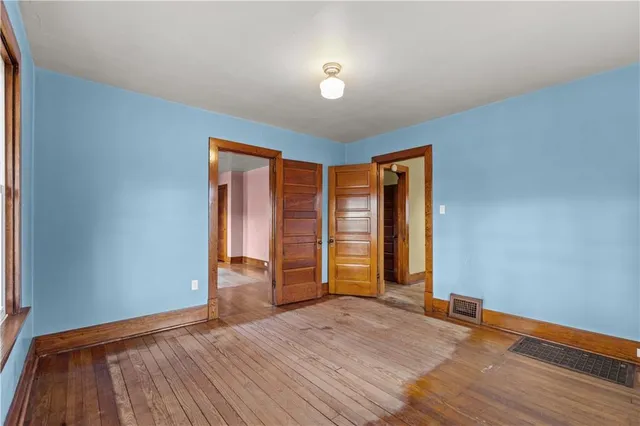 an empty room with wooden floor and closet