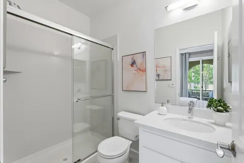 a bathroom with a sink a toilet and shower