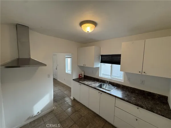 a kitchen with granite countertop a sink and a stove top oven