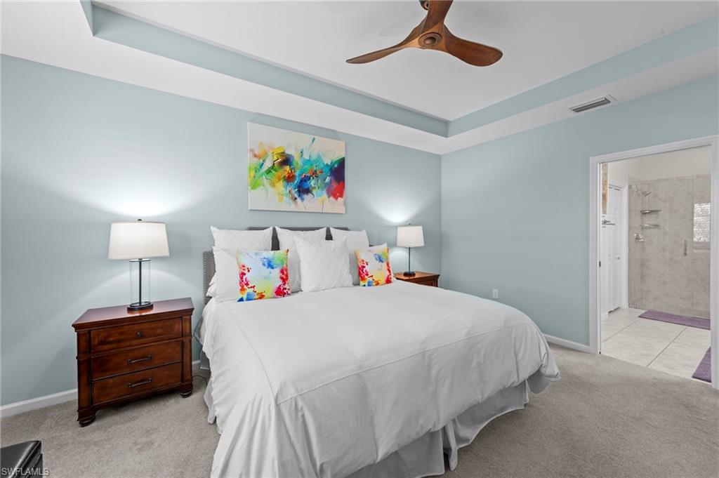 20179 Torch Key Way Estero, FL 33928 - Photo 19 of 41 a bedroom with a bed a rug and a lamp