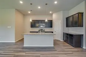 a large kitchen with cabinets a sink and a stove top oven