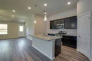 a kitchen with stainless steel appliances granite countertop a sink stove and refrigerator