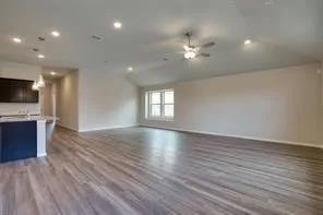 wooden floor in an empty room with a kitchen