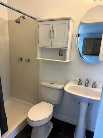 a bathroom with a toilet and a shower