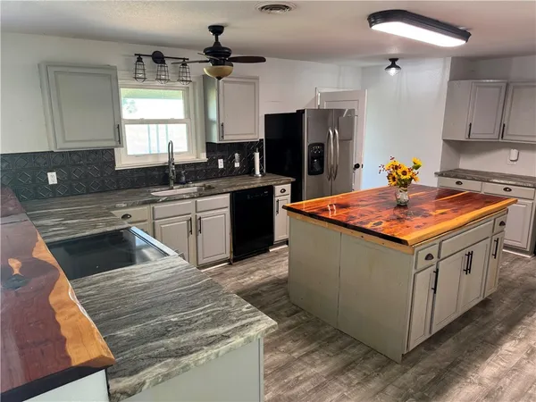 a kitchen with stainless steel appliances granite countertop a stove a sink dishwasher and a refrigerator
