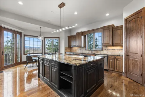 a kitchen with stainless steel appliances granite countertop stove a refrigerator a sink dishwasher with a dining table and chairs