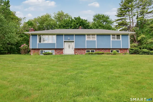 a front view of a house with a yard and trees
