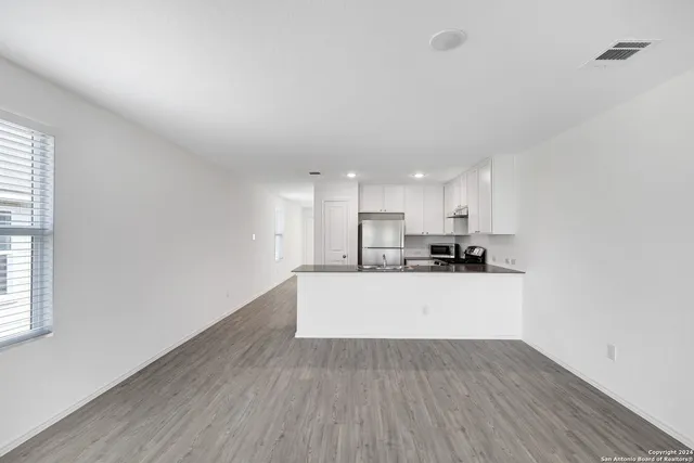 a view of a kitchen with wooden floor a sink and a window