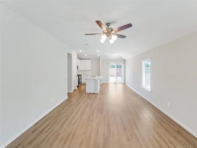 a view of a livingroom with wooden floor and a ceiling fan