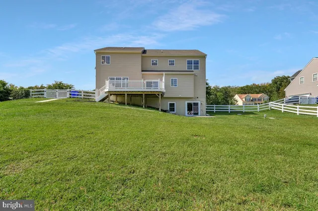 a view of a house with a big yard and large trees