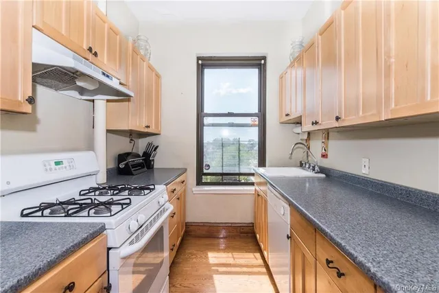 a kitchen with a sink stove top oven and cabinets
