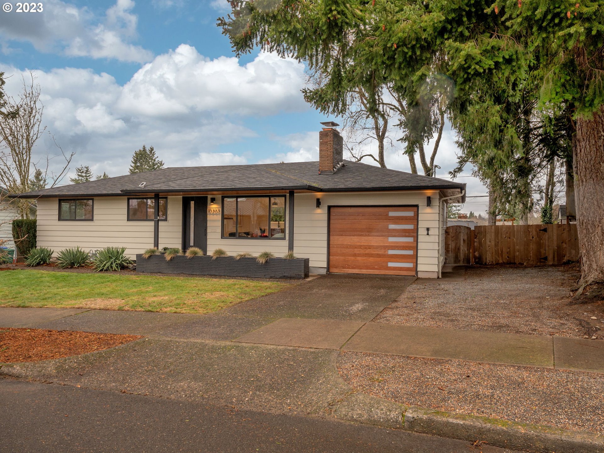 10303 Southeast Stephens Street Portland, OR 97216 - Photo 2 of 32 a front view of a house with a garden and trees