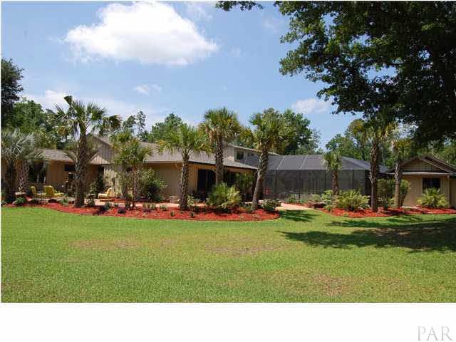 4380 Berryhill Road Pace, FL 32571 - Photo 21 of 24 Over 25 Palm trees surround the main house, detached garage, pool house, fire pit & water fountain.