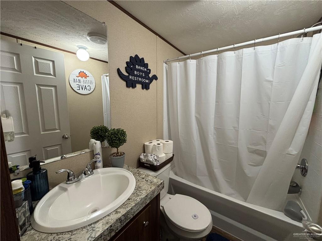 4415 Addison Drive Edinburg, TX 78542 - Photo 11 of 12 Full bath featuring a textured ceiling, vanity, and shower / tub combo with curtain