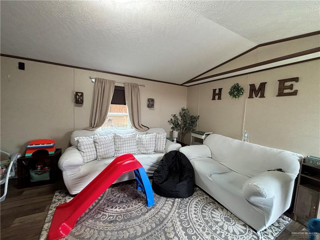 4415 Addison Drive Edinburg, TX 78542 - Photo 2 of 12 Living room with wood finished floors, a textured ceiling, and vaulted ceiling