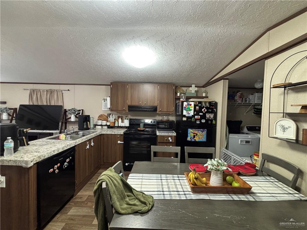 4415 Addison Drive Edinburg, TX 78542 - Photo 3 of 12 Kitchen with black appliances, a textured ceiling, a peninsula, wood finished floors, and light countertops